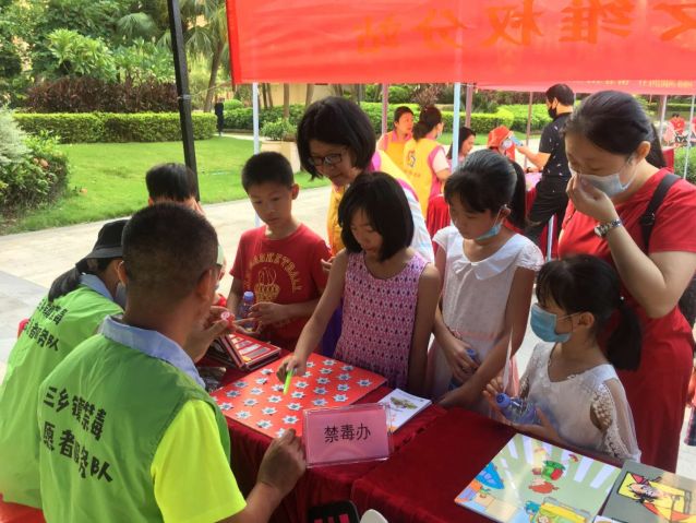 親子家庭在禁毒志愿者的引導(dǎo)下進行禁毒小游戲.jpg